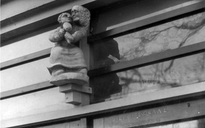 221122 Afbeelding van een beeldje voorstellend een beeldhouwer, waarschijnlijk door Steph Uiterwaal vervaardigd, boven ...